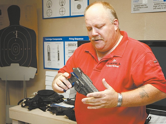 Shannon Litz/Nevada AppealJames Campbell of America West Guns talk about the different holsters available on Thursday in his Carson City shop.