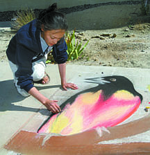 Jim Grant/NEVADA APPEALInspired by nature, Western Nevada College art student Moki Baptista paints with oil chalk on the sidewalk outside the Dini Library and Student Center on Monday.