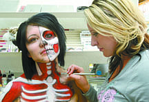 Jim GrantBody paint artist Lynzie Ruecker, right, creates a two-face design on make up tech Carissa Wilson at Spear Me and Hair Studio.