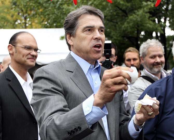 Republican presidential candidate, Texas Gov. Rick Perry reacts after taking a bite of chili during a campaign stop a the Chili Festival Saturday, Oct. 1, 2011, in Manchester, N.H. (AP Photo/Jim Cole)