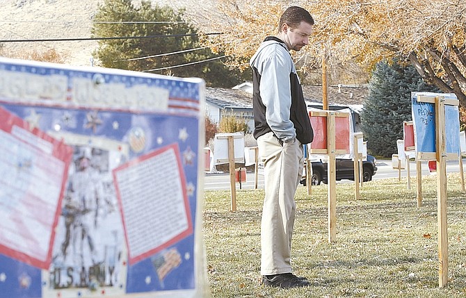 Photos by Shannon Litz/Nevada AppealCarson Middle School social studies teacher and Army veteran Jim Hannah looks at the display on the lawn of of the school Wednesday. Eighth-graders there interviewed veterans then posted their biographies on the placards in front of the school. Community members are invited to view the display through Sunday.