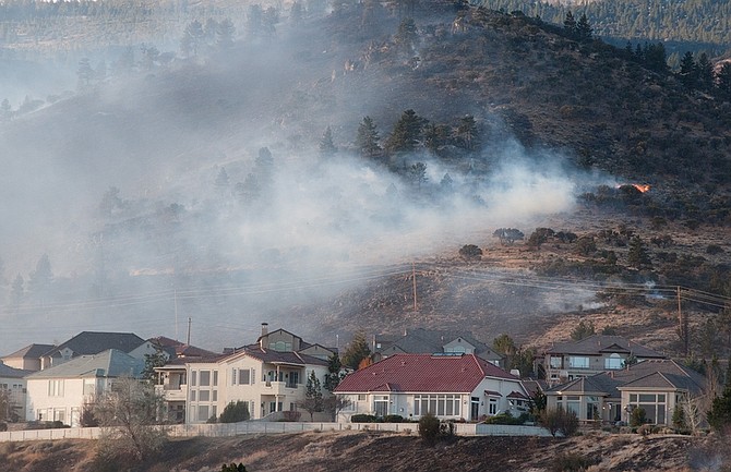 The 400-acre Caughlin Fire burns near homes  in Reno, Nev. on Friday, Nov. 18, 2011. High winds are making it difficult to contain the fire. Officials say at least a dozen homes have been lost, several people have suffered smoke inhalation and one person suffered a cardiac arrest in the fire, which started about 12:30 a.m. in the Caughlin Ranch area and glowed orange on the hillsides through the night.  (AP Photo/Kevin Clifford)