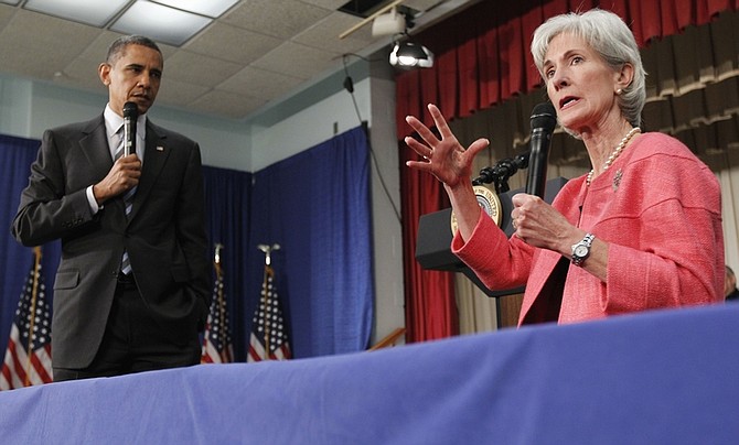 FILE - In this June 8, 2010 file photo, President Barack Obama listens as Health and Human Services Secretary Kathleen Sebelius speaks during a town hall meeting on the Affordable Care Act, at the Holiday Park Multipurpose Senior Center in Wheaton, Md. Medicare&#039;s prescription coverage gap is getting noticeably smaller and easier to manage this year for millions of older and disabled people with high drug costs. The &quot;doughnut hole&quot;will shrink about 40 percent for those unlucky enough to land in it, according to new Medicare figures provided in response to a request from The Associated Press.  (AP Photo/Alex Brandon, File)