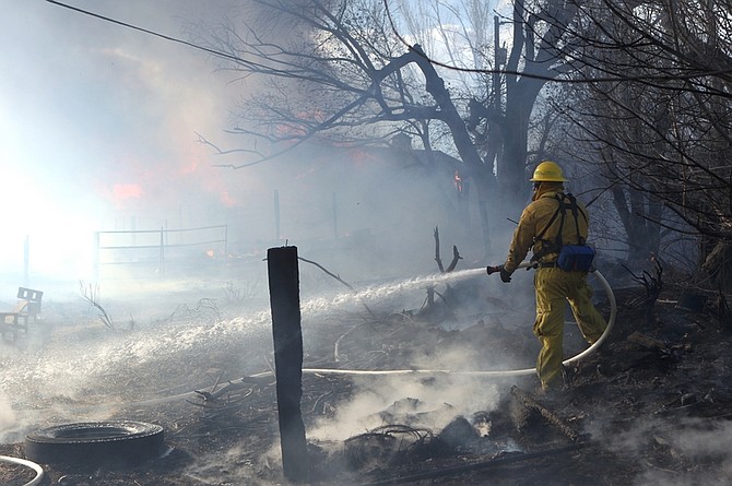 Firefighters battle a 400-acre brush fire in south Reno, Nev., on Friday, Nov. 18, 2011. The fire raged through more than 400 acres, claimed at least one life, injured several others, destroyed dozens of  homes and blanketed Reno and its suburban enclaves in a fiery curtain as violent winds sidelined firefighters and rescue helicopters.  (AP Photo/Cathleen Allison)