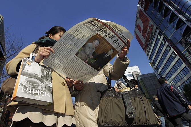 Women read an extra issue of a Japanese newspaper at Ginza district in Tokyo Monday, Dec. 19, 2011. The paper reports Kim, North Korea&#039;s mercurial and enigmatic longtime leader, has died of heart failure. He was 69. (AP Photo/Hiro Komae)