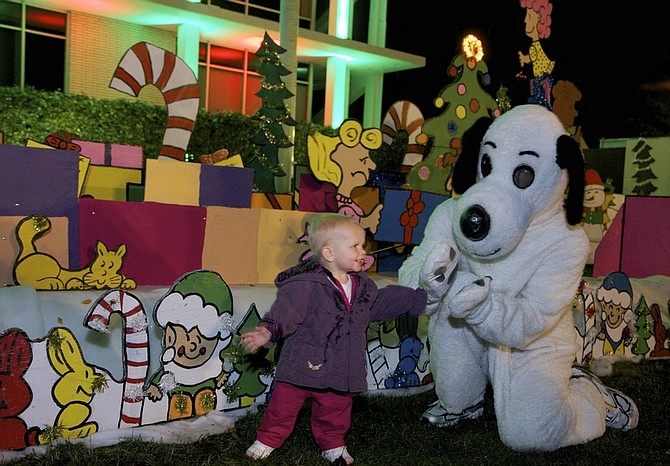 Snoopy greets one-year-old Raeghan Thompson, from Newport Beach, Calif., at the &quot;Snoopy House&quot; display that Jim Jordan started 44 years ago, Tuesday, Dec. 13, 2011, on the lawn outside City Hall in Costa Mesa, Calif. The city of Costa Mesa offered to host the massive, animated display of Charles Schulz&#039;s &quot;Peanuts&quot; Christmas characters after Jordan lost the home where the tradition was born and flourished to foreclosure. The move saved a wildly popular Christmas display that Jordan says draws 80,000 people _ including busloads of visitors, school groups and lines of children waiting to see Santa. (AP Photo/Damian Dovarganes)