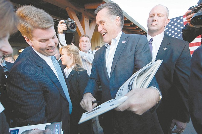 Republican presidential candidate, former Massachusetts Gov. Mitt Romney, shows a picture of himself in his high school yearbook to aide Garrett Jackson, which was handed to him by a member of the audience, at a campaign rally in Reno, Nev., Thursday, Feb. 2, 2012. (AP Photo/Gerald Herbert)