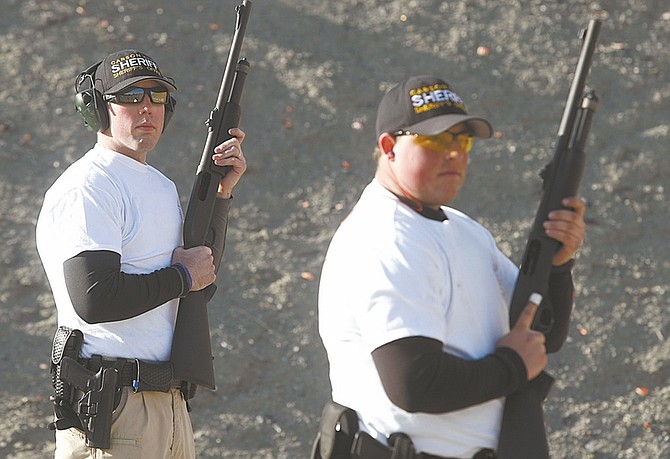 Shannon Litz/Nevada Appeal Carson City Sheriff&#039;s Reserve Sgt. John Miller, left, and Reserve Deputy Steven Passalacqua prepare to shoot during firearms qualification of POST training on Thursday afternoon at the Carson range.