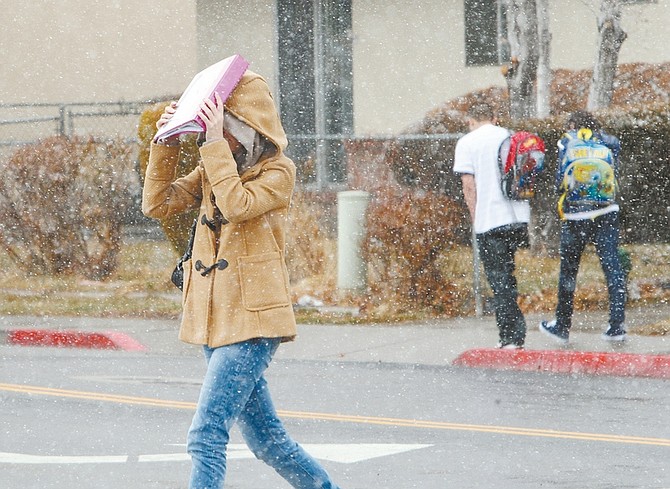 Jim Grant/Nevada AppealA Carson High School student shields her face from the snow with a notebook on Monday afternoon.