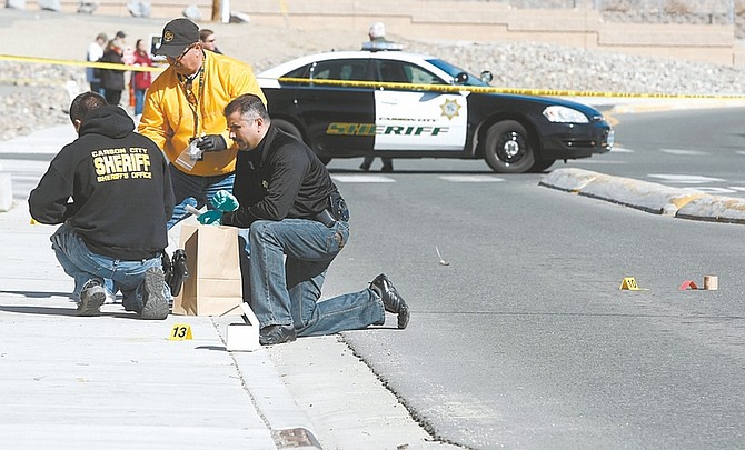 Shannon Litz / Nevada AppealOfficers look for evidence at the scene of a Saturday morning shooting outside Toads Bar.
