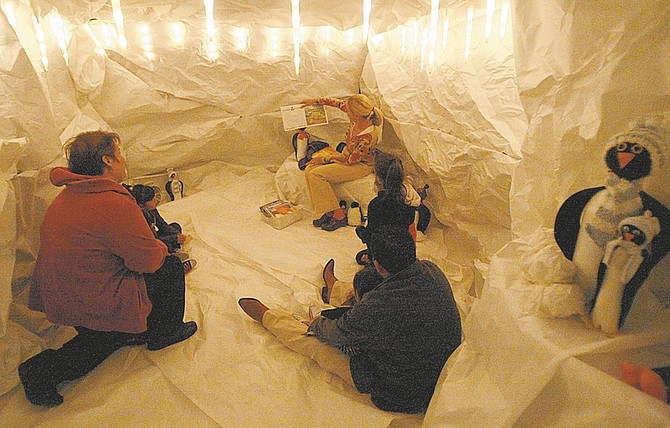 Shannon Litz/Nevada AppealLynnette Conrad of the Carson City School Board reads a story in the snow cave at Empire Elementary School on Thursday night.