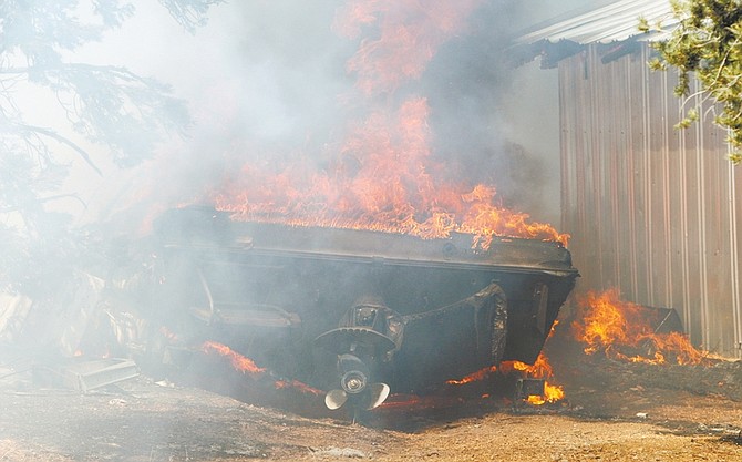 Kurt Hildebrand/Nevada AppealA boat is engulfed in flames in the yard of a residence in Topaz Ranch Estates on Tuesday.