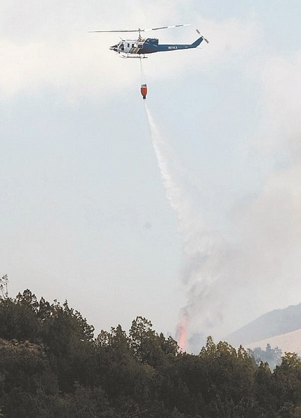 Shannon Litz/Nevada AppealA helicopter drops water on the Carter Springs fire on Saturday afternoon.