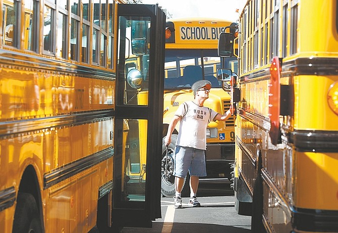 Shannon Litz / Nevada AppealScott McKee checks out his school bus before leaving the bus yard to take students home from school on Friday afternoon. The Carson City School District is facing a $5.5 million budget shortfall next year.