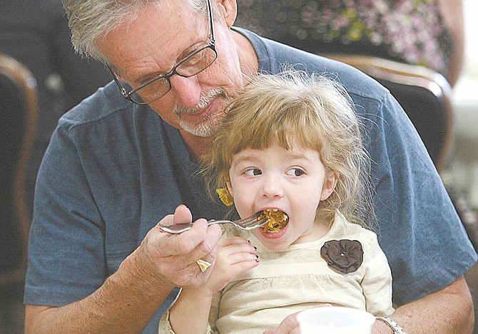 Photos by Shannon Litz / Nevada AppealEarl Britt shares a bite of pumpkin pie with his 3-year-old granddaughter, Samantha Grace Smith, on Thursday at the Carson Nugget.
