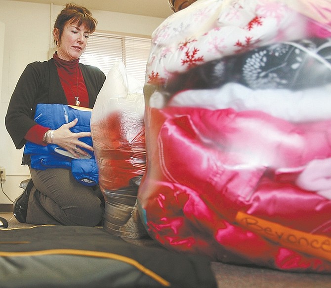 Jim Grant / Nevada AppealPeggy Sweetland, special projects coordinator for the Carson City School District, folds and packs children&#038;#8217;s winter jackets for delivery to area schools on Tuesday.