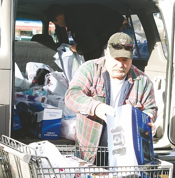 Wheeler Cowperthwaite / Nevada AppealRetired firefighter Ed Young loads presents and toys into a Salvation Army van Tuesday morning.
