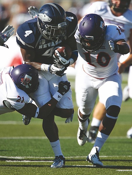 Nevada&#039;s Brandon Wimberly (4) tries to break free from Northwestern State&#039;s Bert White (10) and Brashard Booker (21) during the first half of an NCAA college football game Saturday, Sept. 15, 2012, in Reno, Nev. (AP Photo/Cathleen Allison)