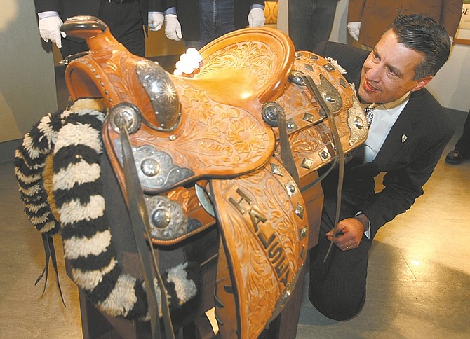 Shannon Litz / Nevada AppealNevada Gov. Brian Sandoval reads the inscription on the back of the Admiral William &#038;#8220;Bull&#038;#8221; Halsey saddle on Thursday at the Nevada State Museum.