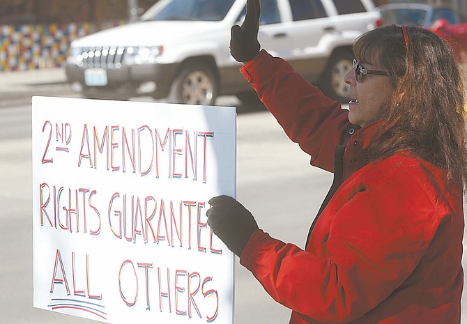 Photos by Shannon Litz / Nevada AppealLinda Foster of Gardnerville waves to cars in front of the Legislature. Foster took part in the &#038;#8220;Guns Across America&#038;#8221; rally in support of Second Amendment rights.