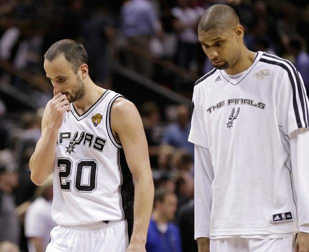 San Antonio Spurs&#039; Manu Ginobili, of Argentina,, left, and Tim Duncan leave the floor after losing to the Miami Heat at Game 4 of the NBA Finals basketball series, Thursday, June 13, 2013, in San Antonio. The Heat won 109-93. (AP Photo/Eric Gay)