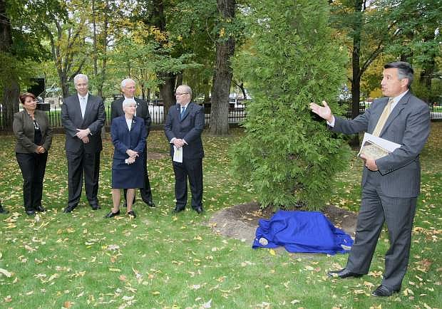 Nevada 150 Commission members look on as Gov. Brian Sandoval dedicates a Incense Cedar tree and plaque during a ceremony on the Capitol grounds on Tuesday.