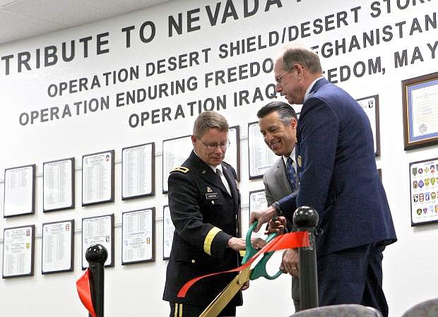 Brigadier General Michael Hanifan, Governor Brian Sandoval and Brigadier General William Burks cut the ribbon at the unveiling of the Nevada National Guard combat veteran tribute wall at the Office of the Adjutant General Friday in Carson City.