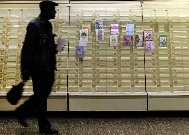 In this April 27, 2013 photo, a man walks past a greeting cards display case in a market in Baltimore. America as a whole has regained all the household wealth it lost to the Great Recession and then some, thanks to higher stock and home prices. (AP Photo/Patrick Semansky)