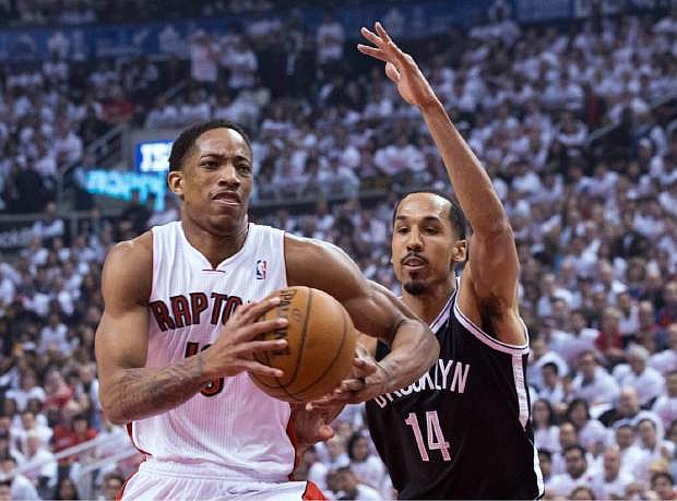 Toronto Raptors&#039; DeMar DeRozan, left, drives on Brooklyn Nets&#039; Shaun Livingston during the first half of Game 1 of an opening-round NBA basketball playoff series, in Toronto on Saturday, April 19, 2014. (AP Photo/The Canadian Press, Chris Young)