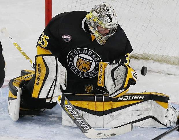 Colorado College goalie Chase Perry watches the puck sail by for a goal on a shot by Denver forward Matt Marcinew in the second period of an NCAA college hockey game in Denver on Friday, Nov. 14, 2014. (AP Photo/David Zalubowski)