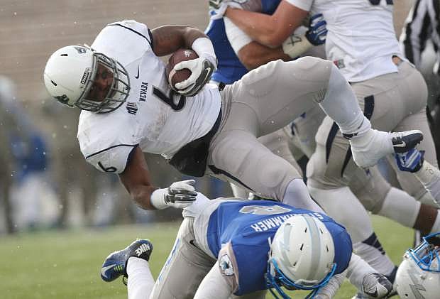 Nevada running back Don Jackson, top, gets flipped over by Air Force defensive back Weston Steelhammer in the third quarter of Air Force&#039;s 45-38 overtime victory in an NCAA college football game at Air Force Academy, Colo., on Saturday, Nov. 15, 2014. (AP Photo/David Zalubowski)