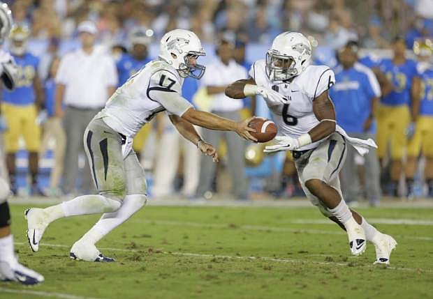 Nevada quarterback Cody Fajardo hands off to running back Don Jackson during the first half of an NCAA college football game against UCLA  in Pasadena, Calif., Saturday, Aug. 31, 2013. (AP Photo/Chris Carlson)