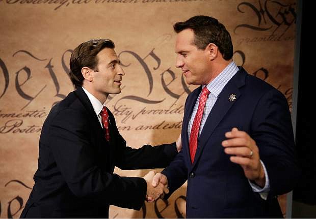 Adam Laxalt, left, shakes hands with Nevada Secretary of State Ross Miller before they debate Friday, Oct. 10, 2014, in Las Vegas. Laxalt and Miller are facing each other in a race for attorney general in Nevada. (AP Photo/John Locher)