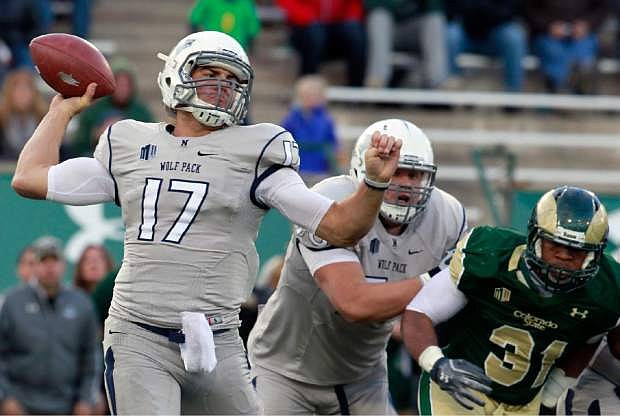 Nevada quarterback Cody Fajardo, left, rolls out to pass the ball as offensive lineman Joel Bitonio, center, blocks Colorado State linebacker Cory James in the fourth quarter of an NCAA college football game in Fort Collins, Colo., on Saturday, Nov. 9, 2013. (AP Photo/David Zalubowski)