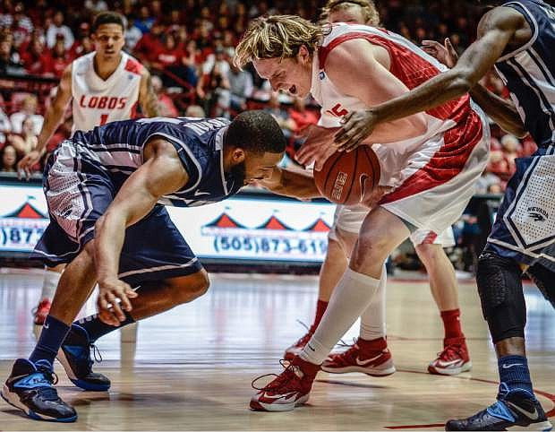 New Mexico&#039;s Cameron Bairstow ,right, and Nevada&#039;s Deonte Burton vie for a loose ball under the basket during an NCAA college basketball game Saturday, Feb. 15, 2014, in Albuquerque, N.M. New Mexico won 90-72. (AP Photo/Albuquerque Journal, Roberto E. Rosales) SANTA FE NEW MEXICAN OUT