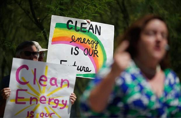People hold up signs during a news conference in support of the EPA&#039;s clean power plan, Monday, Aug. 3, 2015, in Las Vegas. (AP Photo/John Locher)