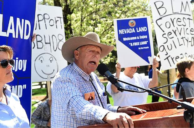 Nevada rancher Cliven Bundy, center, addresses the crowd after arriving at the Nevada State Legislature building to rally behind a bill seeking to reclaim land from the federal government Tuesday, March 31, 2015, in Carson City, Nev. Bundy garnered national attention a year ago when he and armed supporters engaged in a showdown with federal authorities. (AP Photo/The Reno Gazette-Journal, Jason Bean)  NO SALES; NEVADA APPEAL OUT; SOUTH RENO WEEKLY OUT