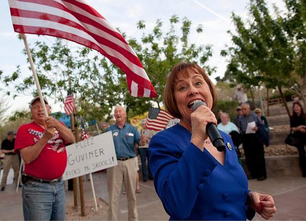 File - In this April 15, 2011 file photo, Sharron Angle, right, sings during a rally by Tea Party supporters in Las Vegas. Nevada conservative Angle says she&#039;s trying to determine if she could raise enough money to run for the U.S. Senate again, a move that could throw a wrench in Republicans&#039; hopes to claim Democratic Sen. Harry Reid&#039;s soon-to-be-vacant seat. (AP Photo/Julie Jacobson, file)