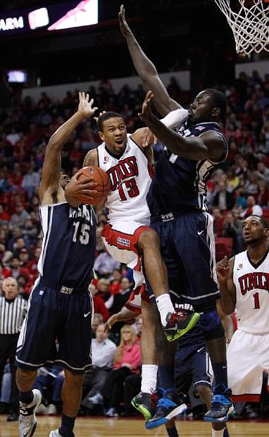 UNLV&#039;s Bryce Dejean-Jones tries for a shot against Nevada&#039;s D.J. Fenner, left, and Ali Fall, right, during an NCAA college basketball game Wednesday, Jan. 8, 2014, in Las Vegas. (AP Photo/Las Vegas Review-Journal, John Locher)