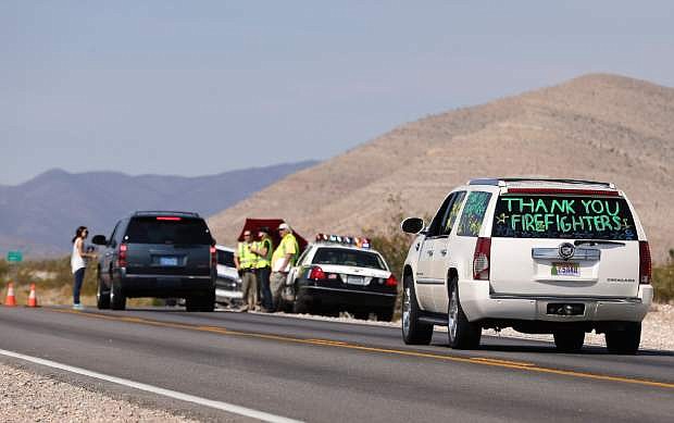 Motorists pass through a checkpoint on state route 157 returning to their homes in Kyle Canyon, Wednesday, July 17, 2013, near Las Vegas. Residents are heading back to mountain hamlets once threatened by a massive wildfire which began July 1, on Mount Charleston northwest of Las Vegas. Police were operating checkpoints for more than 400 people due to return to the Old Town, Rainbow and Echo communities in Kyle Canyon. (AP Photo/Julie Jacobson)