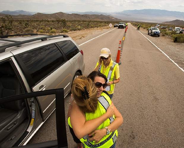 Lee Canyon resident JaeAnn Bernhardt hugs Metropolitan Police volunteer Linda Fleming, left, while Lauren Olson looks on at the Lee Canyon check point on July 12, 2013. Residents were returning home Monday, July 15, 2013 after more than a week evacuated from Mount Charleston hamlets northwest of Las Vegas, where authorities were reporting 70 percent containment of a huge wildfire that has been burning since July 1. (AP Photo/Las Vegas Review-Journal, Jeff Scheid)