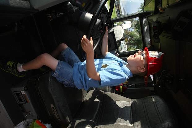 Dylan Reyes, 6, is thrilled to sit behind the wheel of a Carson City firetruck at the National Night Out community event on Tuesday.