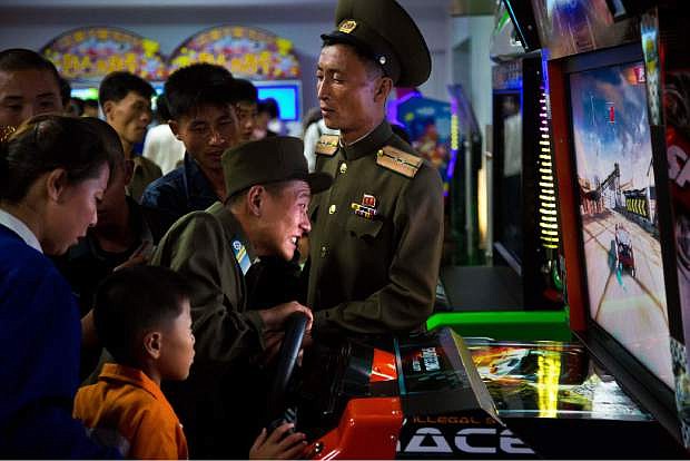 In this Sunday, Sept. 22, 2013 photo, North Koreans soldiers play an arcade game at the Pyongyang Pleasure park in Pyongyang, North Korea. North Korean authorities have been encouraging a broader interest in sports in the country, both at the elite and recreational levels, as a means of energizing and mobilizing the masses. (AP Photo/David Guttenfelder)