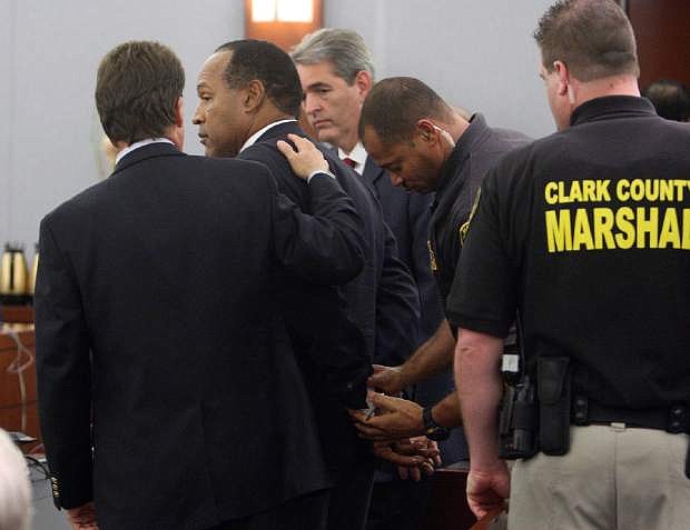FILE - In this Friday, Oct. 3, 2008 file photo, O.J. Simpson is handcuffed after a verdict of guilty on all counts was read following his trial at the Clark County Regional Justice Center in Las Vegas. The verdict comes 13 years to the day after Simpson was acquitted of murdering his ex-wife Nicole Brown Simpson and Ron Goldman. The return of O.J. Simpson to a Las Vegas courtroom next Monday, May, 13,  will remind Americans of a tragedy that became a national obsession and in the process changed the country&#039;s attitude toward the justice system, the media and celebrity. The return of O.J. Simpson to a Las Vegas courtroom next Monday, May, 13,  will remind Americans of a tragedy that became a national obsession and in the process changed the country&#039;s attitude toward the justice system, the media and celebrity. (AP Photo/Steve Marcus, Pool)