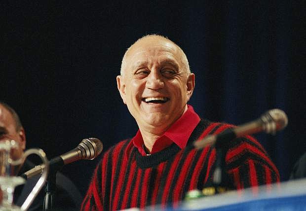 FILE - In this April 2, 1990, file photo UNLV head coach Jerry Tarkanian flashes a big smile during a press conference prior to facing Duke in the NCAA Final Four in Denver. Hall of Fame coach Jerry Tarkanian, who built a basketball dynasty at UNLV but was defined more by his decades-long battle with the NCAA, died Wednesday, Feb. 11, 2015, in Las Vegas after several years of health issues. He was 84. (AP Photo/Eric Risberg, File)