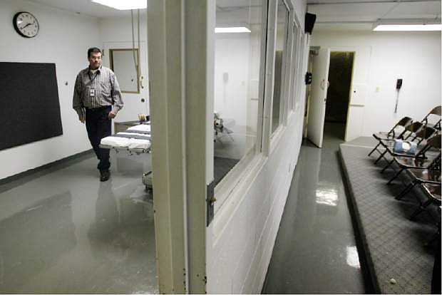 FILE - In this Tuesday, April 15, 2008 file photo, Terry Crenshaw, wardens assistant at the Oklahoma State Penitentiary, walks past the gurney in the execution chamber at left, in McAlester, Okla. At right are the rows of chairs in which witnesses to executions are seated. Oklahoma prison officials tried for 51 minutes to find a vein in a death row inmate&#039;s arms and feet before inserting an IV through the man&#039;s groin ahead of a botched execution this week, the state&#039;s prisons chief said Thursday in a report urging more oversight of executions. (AP Photo)