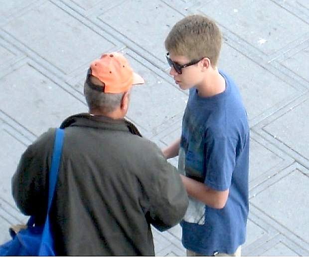 Carson High School student Jason Peck offers a traveler the Bible in Arabic.