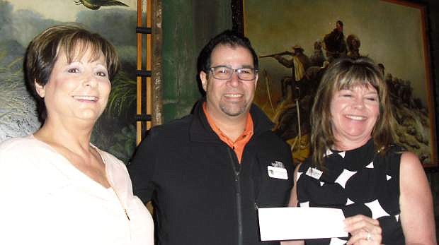 Angela LoGiurato, left, and Cynthia Bunt, right, both of Professional Saleswomen of Nevada, present a $215 check for to Kevin Frausto, Reno director of Project 150, an organization that helps homeless high school students in Reno and Las Vegas.