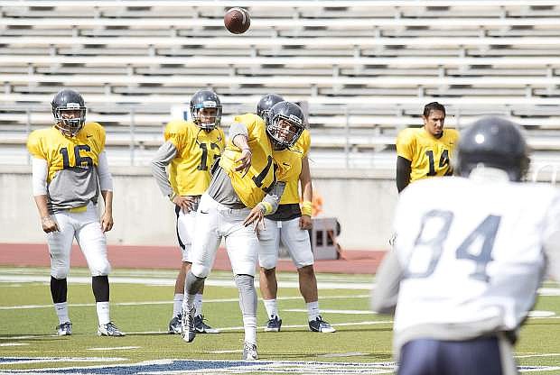 Nevada redshirt freshman quarterback Hunter Fralick unleashes a throw to Jerico Richardson, while the team&#039;s quarterbacks look on, during Saturday&#039;s open practice at Mackay Stadium in Reno.