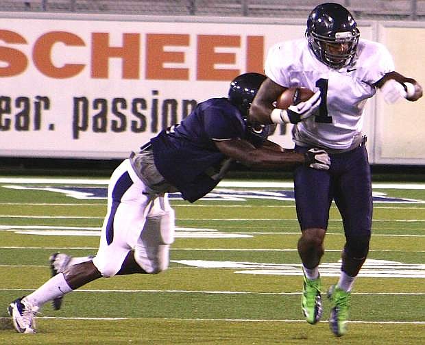 Nevada wide receiver Brandon Wimberly tries to escape from Randy Uzoma during the team&#039;s first scrimmage of the season on Saturday at Mackay Stadium in Reno.